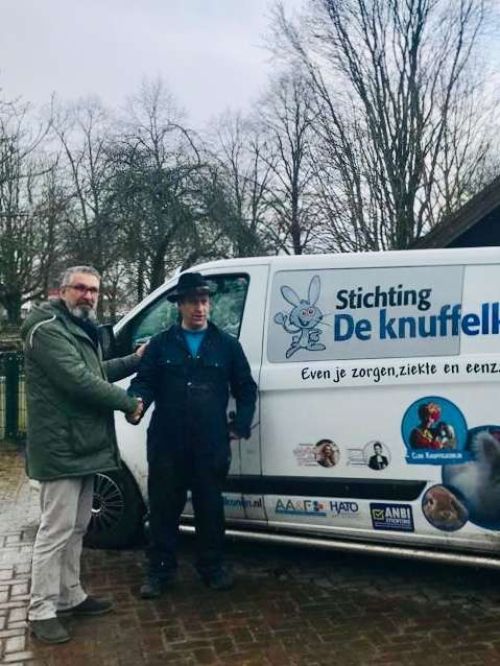 Handen worden geschud voor het busje van de stichting de Knuffelkonijn